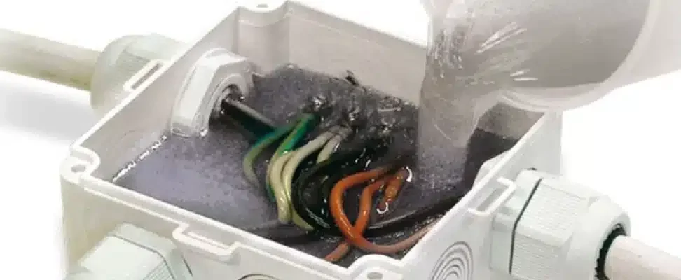 Boite de dérivation en train d'être remplie de gel d'isolation électrique.