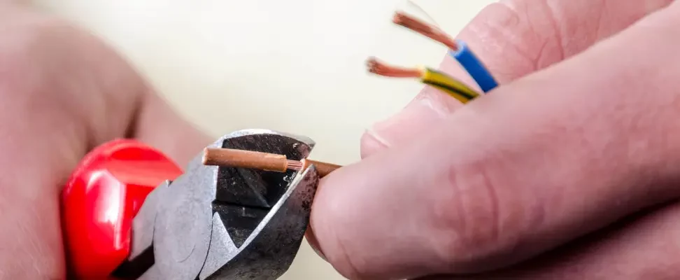 pour-couper-des-cables-electriques-2 Gros plan sur des fils en train d'être dénudés au niveau des extrémités.